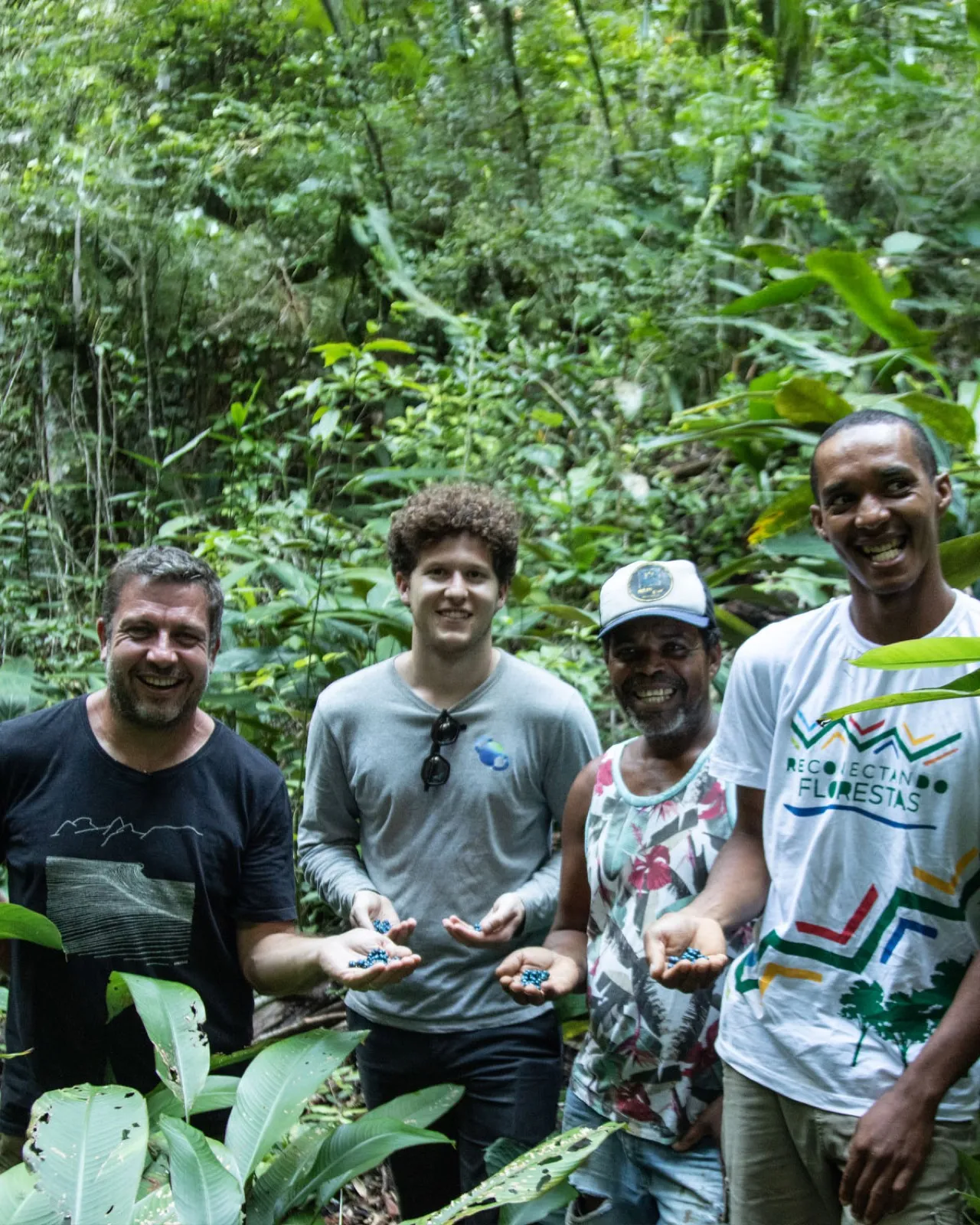 MORFO team and local partners holding native seed pods in the forest