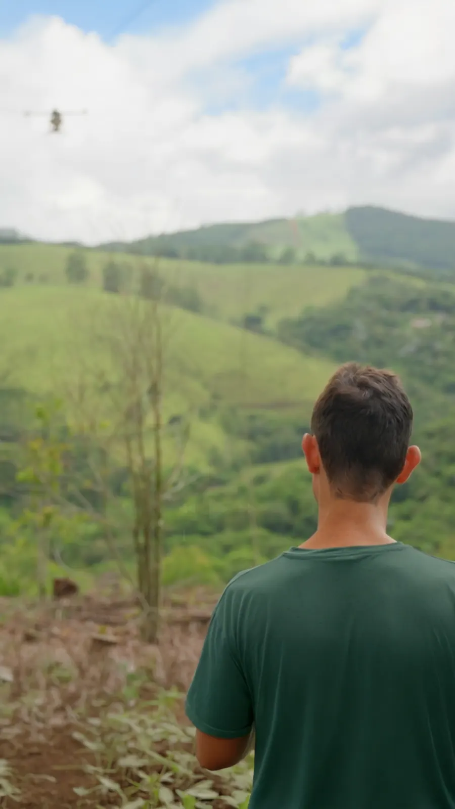 A pilot flying the seeding drone over the São Paulo hills